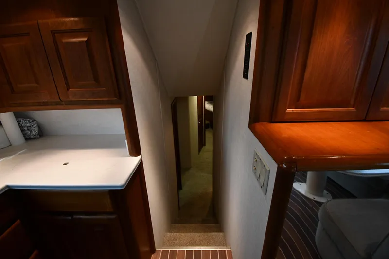 Slide: The Image of Interior view of 1990 Viking 53 Convertible yacht, featuring wooden cabinetry and narrow hallway. - 44