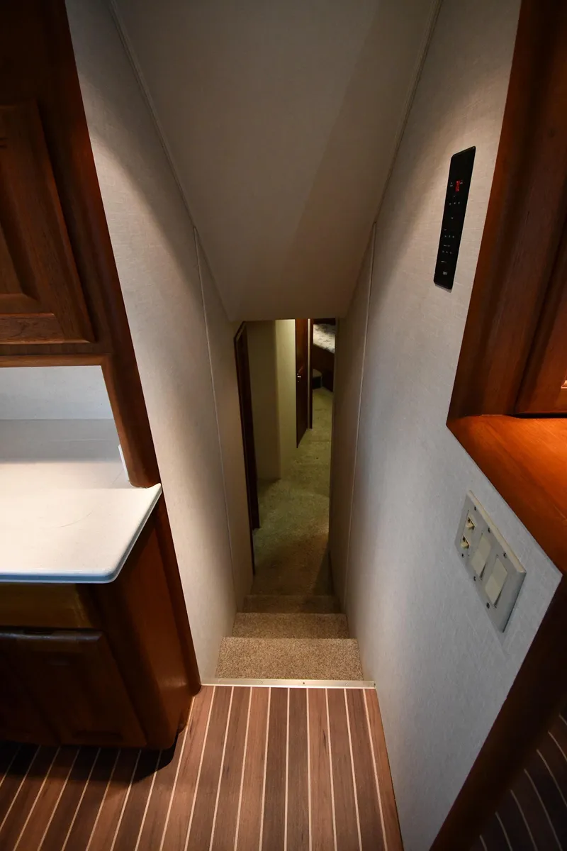 Slide: The Image of Interior view of 1990 Viking 53 Convertible yacht, featuring narrow staircase and wooden cabinetry. - 45