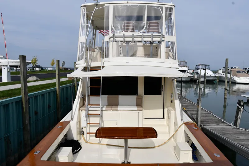 Slide: The Image of 1990 Viking 53 Convertible yacht docked at marina, rear view showing deck and upper seating area. - 5