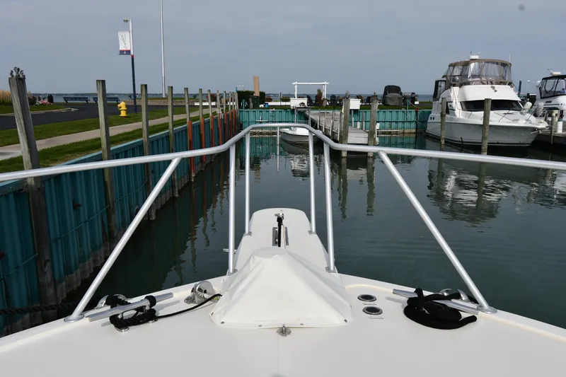 Slide: The Image of Bow view of a 1990 Viking 53 Convertible yacht docked in a marina. - 9
