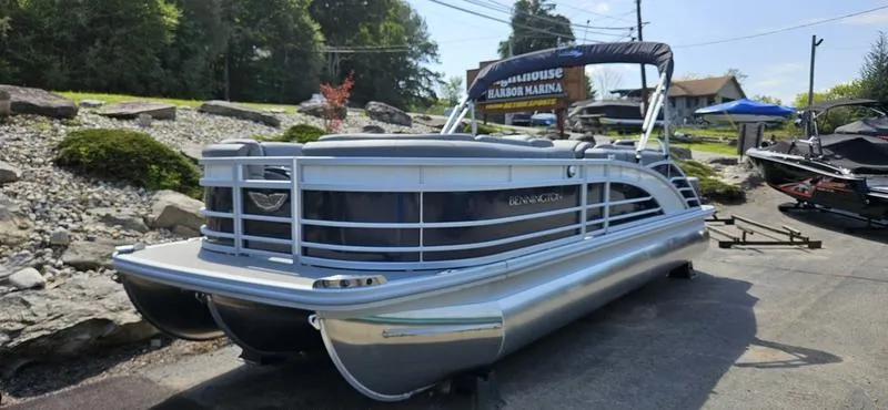 Slide: The Image of 2025 Bennington 23 RSB pontoon boat displayed outdoors at a marina. - 0