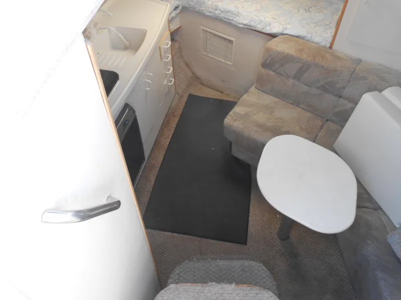 Slide: The Image of Interior of a 1995 Larson 280 Cabrio boat with seating and kitchenette. - 12