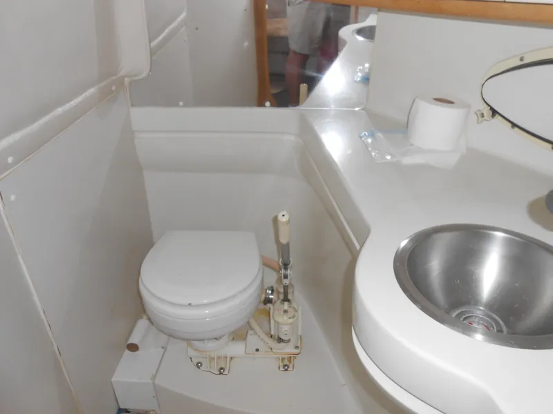 Slide: The Image of 1995 Larson 280 Cabrio boat bathroom with toilet and sink. - 13