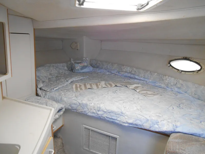 Slide: The Image of 1995 Larson 280 Cabrio cabin interior with bed and porthole window. - 15