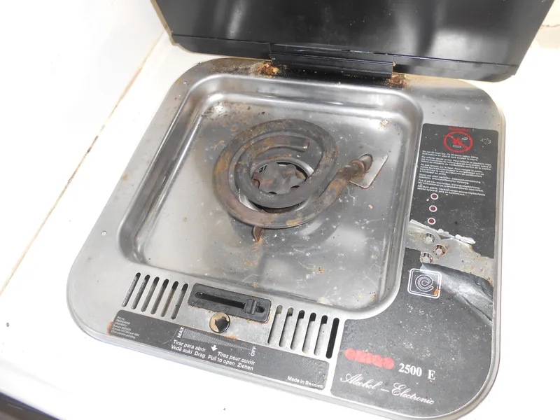 Slide: The Image of 1995 Larson 280 Cabrio stove with single electric burner, showing signs of wear. - 18