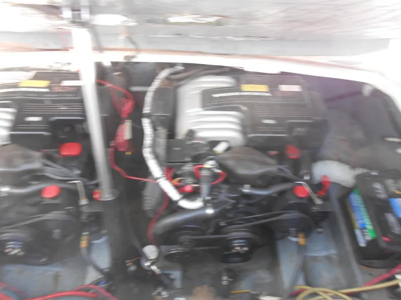Slide: The Image of Engine compartment of a 1995 Larson 280 Cabrio boat, featuring dual engines and wiring. - 25