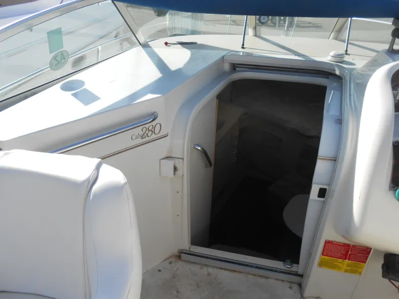 Slide: The Image of 1995 Larson 280 Cabrio boat interior entrance with seating and cabin access. - 9