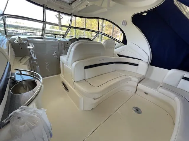 Slide: The Image of 2005 Sea Ray 390 Sundancer interior with white seating and modern helm. - 10