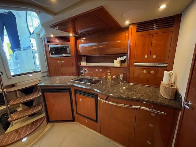 Slide: The Image of Luxurious 2005 Sea Ray 390 Sundancer yacht kitchen with wood cabinetry and modern appliances. - 19