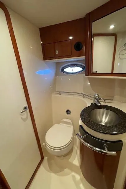 Slide: The Image of 2005 Sea Ray 390 Sundancer bathroom with modern fixtures and porthole window. - 26