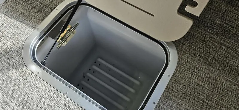 Slide: The Image of Bennington R 25 RSBA 2025 storage compartment with open hatch on textured flooring. - 16