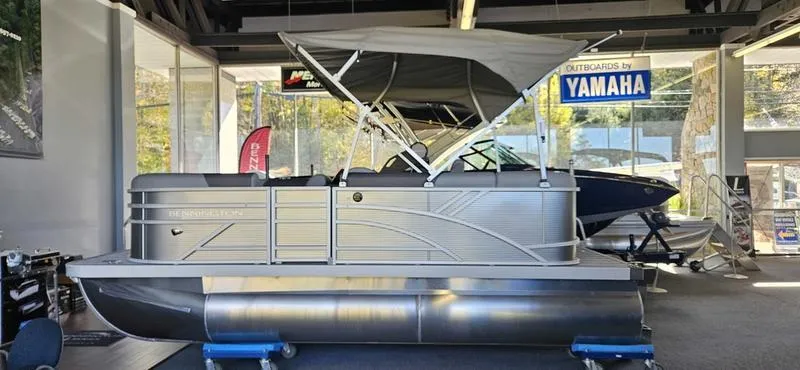 Slide: The Image of 2025 Bennington 168 SL pontoon boat displayed indoors with Yamaha signage. - 0