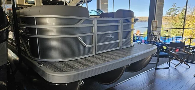 Slide: The Image of 2025 Bennington 168 SL pontoon boat displayed indoors with lake view background. - 1