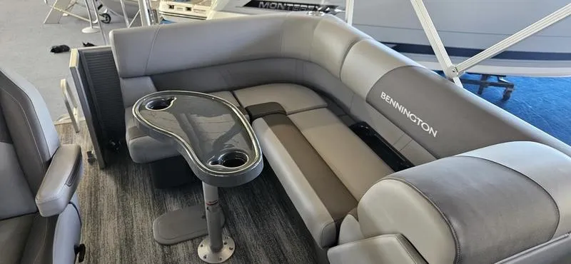 Slide: The Image of 2025 Bennington 168 SL boat interior with gray seating and a sleek table. - 6