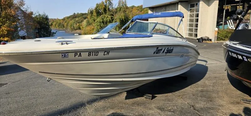 Slide: The Image of 2001 Sea Ray 230 Bow Rider boat with blue canopy, parked outdoors. - 2