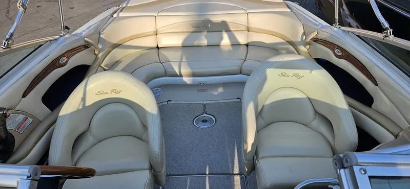 Slide: The Image of 2001 Sea Ray 230 Bow Rider interior with cream leather seating and wood accents. - 5