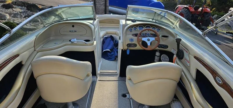 Slide: The Image of Interior of a 2001 Sea Ray 230 Bow Rider boat with beige seating and dashboard. - 8