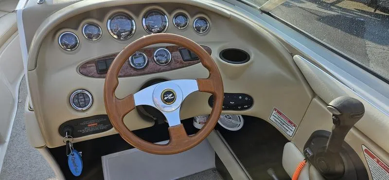 Slide: The Image of 2001 Sea Ray 230 Bow Rider dashboard with wood steering wheel and instrument panel. - 9