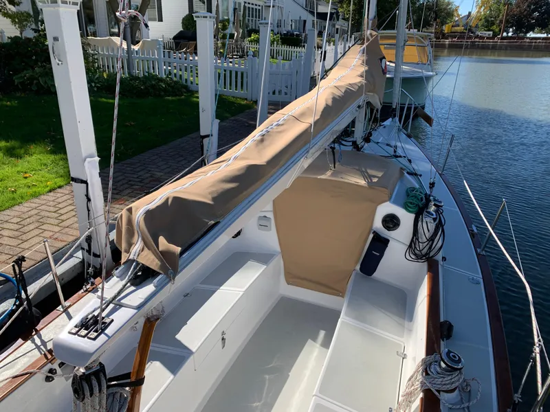 Slide: The Image of 2022 Tartan Fantail sailboat docked by a waterfront home, featuring a covered boom. - 11