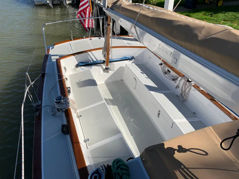 Slide: The Image of 2022 Tartan Fantail sailboat with beige canopy, docked by the water. - 12