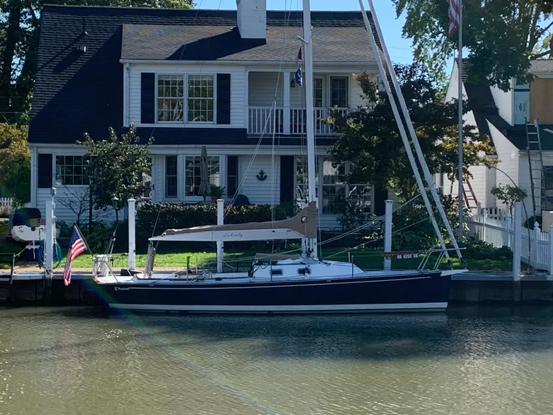 Slide: The Image of Sailboat Tartan Fantail 2022 docked by a charming waterfront house. - 16