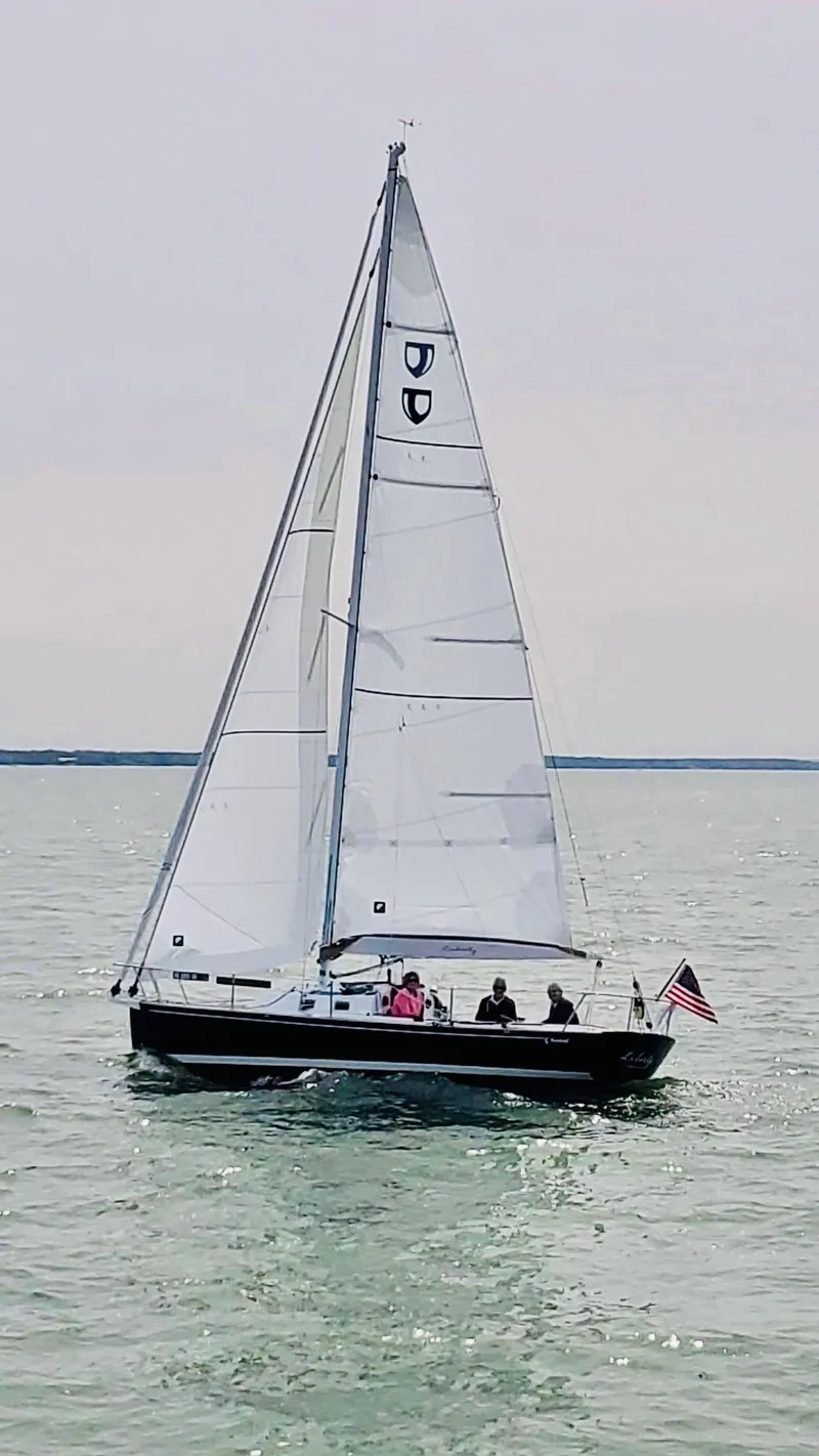 Slide: The Image of 2022 Tartan Fantail sailboat on calm waters with American flag. - 19