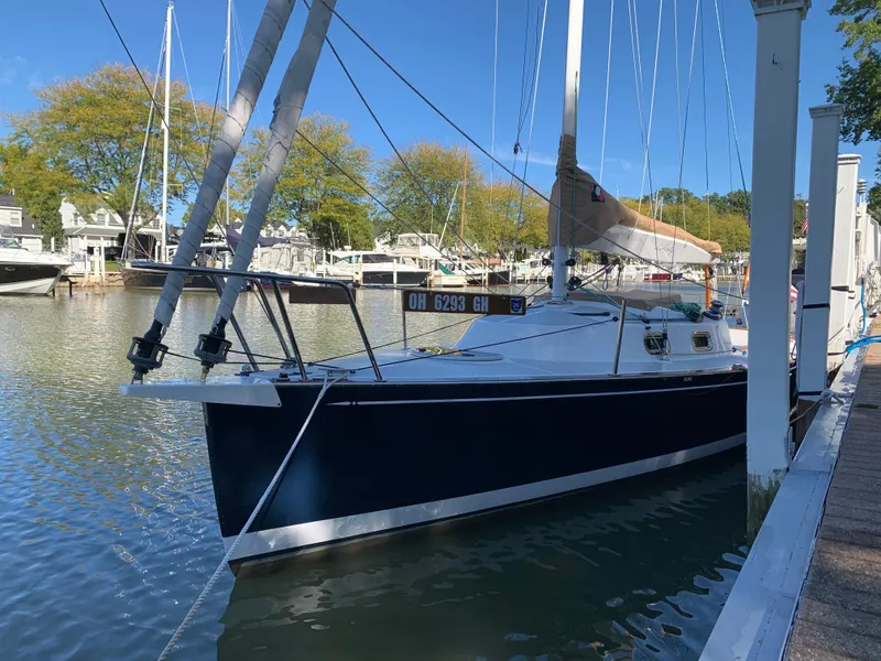 Slide: The Image of Sailboat docked in marina, 2022 Tartan Fantail, calm water, clear sky, trees in background. - 2