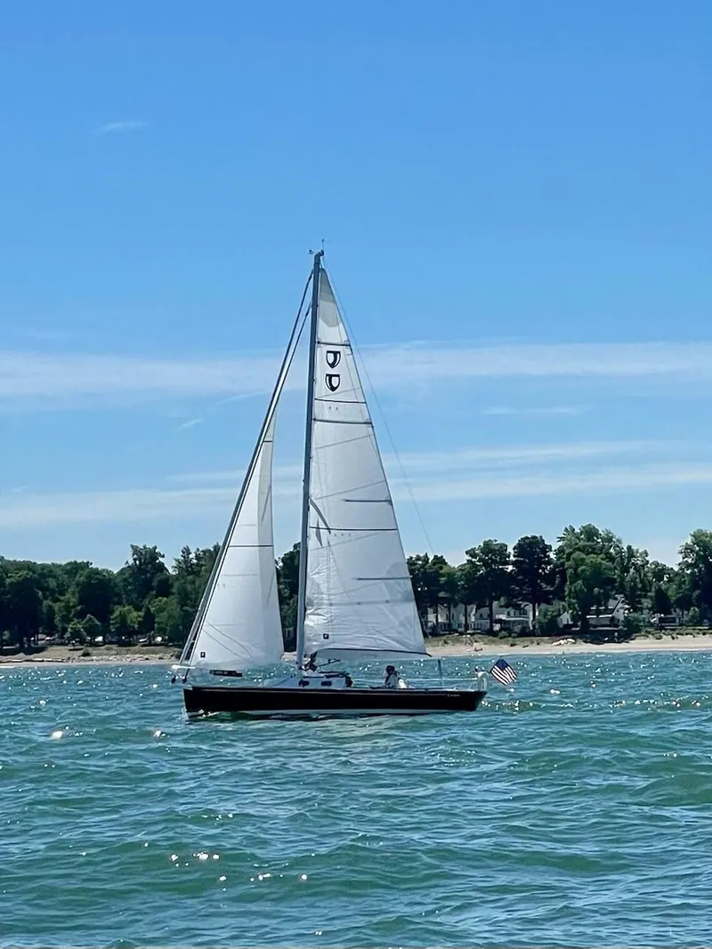 Slide: The Image of Sailboat Tartan Fantail 2022 on a sunny day, sailing near a tree-lined shore. - 20