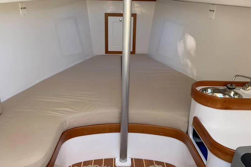 Slide: The Image of 2022 Tartan Fantail interior cabin with bed, sink, and wooden accents. - 24
