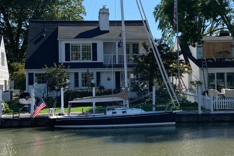 Slide: The Image of Sailboat Tartan Fantail 2022 docked by a charming waterfront house. - 32