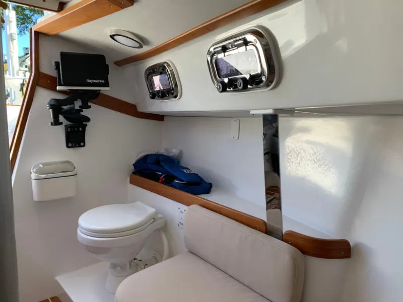 Slide: The Image of Interior of 2022 Tartan Fantail boat with toilet, seating, and portholes. - 6