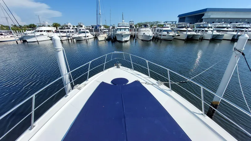 Slide: The Image of 2006 Cruisers Yachts 52 Express docked in a marina, surrounded by other boats. - 10