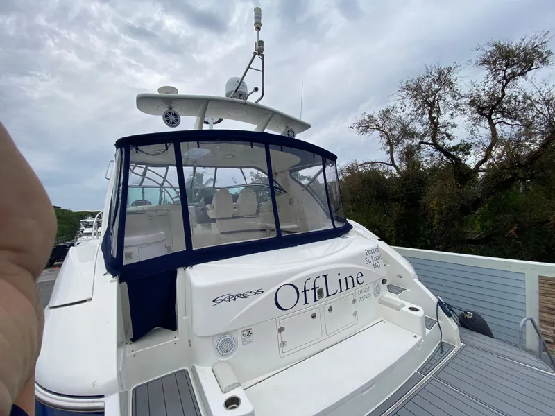 Slide: The Image of 2006 Cruisers Yachts 52 Express docked, rear view with "OffLine" name visible. - 100