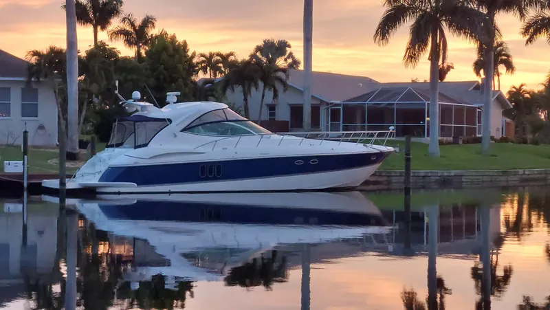 Slide: The Image of 2006 Cruisers Yachts 52 Express docked at sunset, reflecting on calm water. - 11