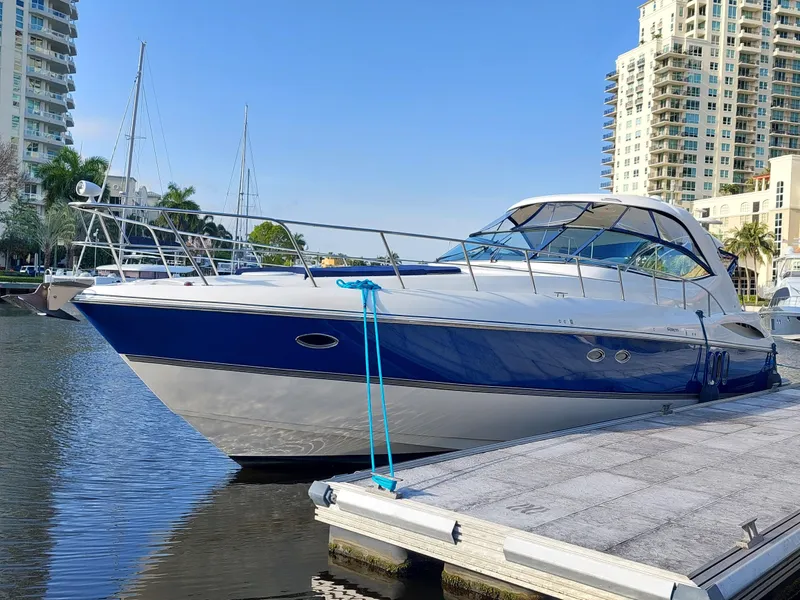 Slide: The Image of 2006 Cruisers Yachts 52 Express docked in a marina, surrounded by tall buildings. - 15