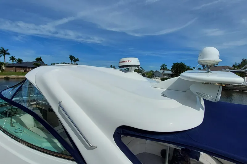 Slide: The Image of 2006 Cruisers Yachts 52 Express, sleek design, docked under clear blue sky. - 17