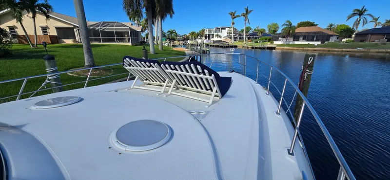 Slide: The Image of 2006 Cruisers Yachts 52 Express on a serene canal with sun loungers. - 30