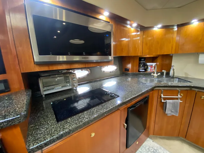 Slide: The Image of Luxurious 2006 Cruisers Yachts 52 Express kitchen with modern appliances and sleek countertops. - 48