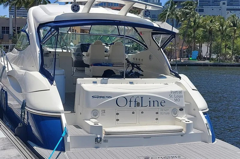 Slide: The Image of 2006 Cruisers Yachts 52 Express docked, featuring "OffLine" nameplate, in a sunny marina setting. - 5