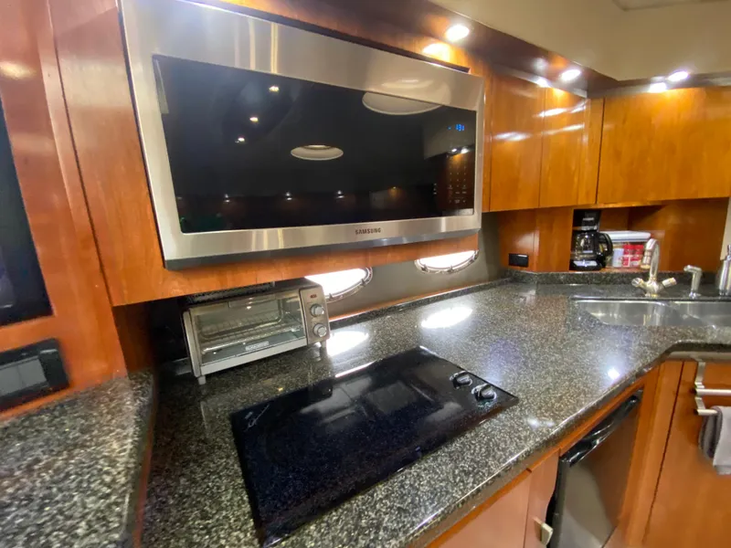 Slide: The Image of Luxurious 2006 Cruisers Yachts 52 Express kitchen with modern appliances and sleek countertops. - 50