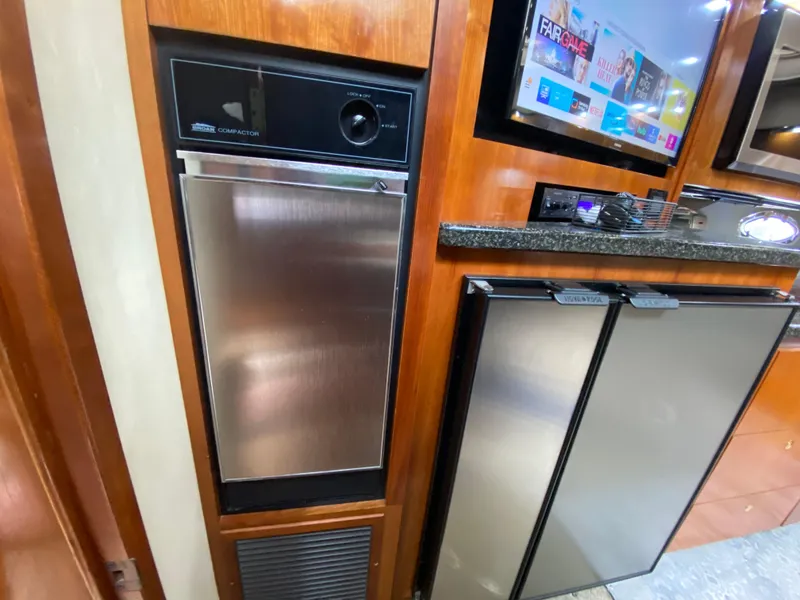 Slide: The Image of 2006 Cruisers Yachts 52 Express kitchen with stainless steel appliances and wood cabinetry. - 52