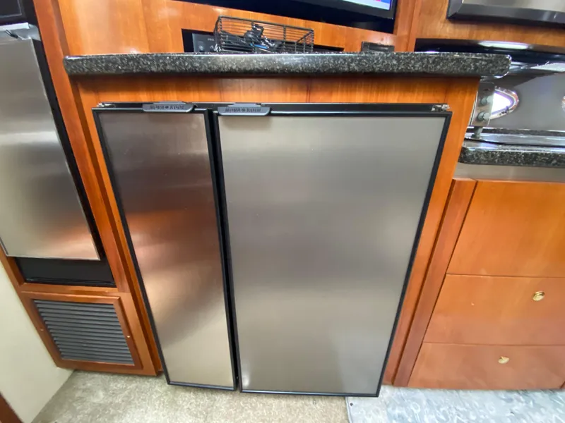Slide: The Image of Stainless steel refrigerator in 2006 Cruisers Yachts 52 Express kitchen area. - 53