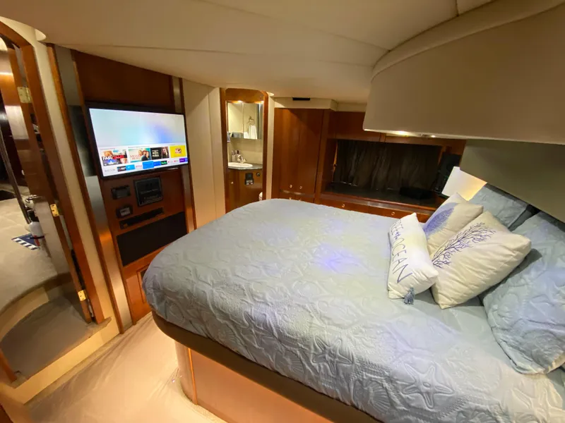 Slide: The Image of Luxurious bedroom in 2006 Cruisers Yachts 52 Express with TV and elegant bedding. - 57