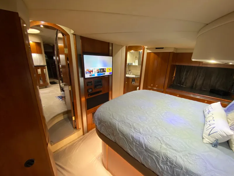 Slide: The Image of Luxurious 2006 Cruisers Yachts 52 Express cabin with cozy bed and modern amenities. - 58