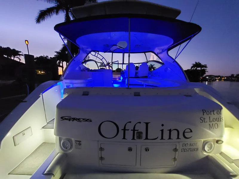 Slide: The Image of 2006 Cruisers Yachts 52 Express at dusk, illuminated with blue lights, named "OffLine." - 6