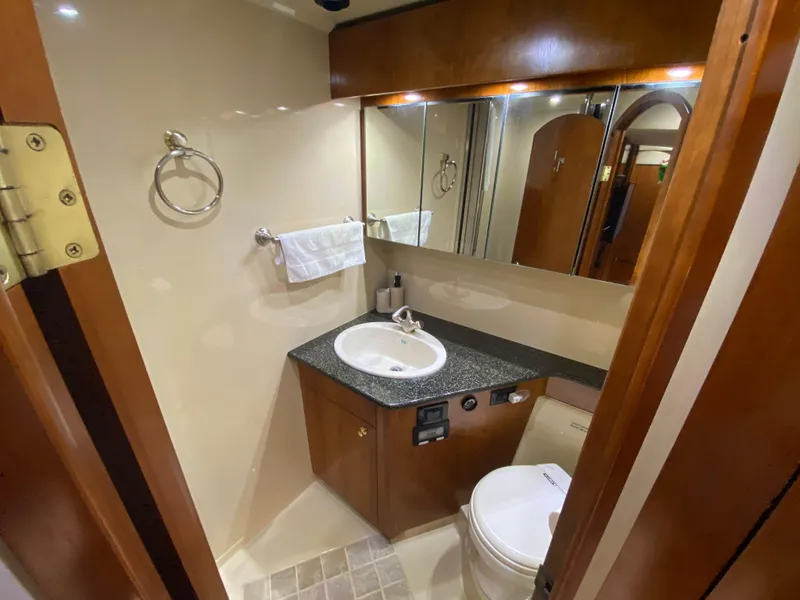 Slide: The Image of Luxurious bathroom in 2006 Cruisers Yachts 52 Express with modern fixtures and wood accents. - 60