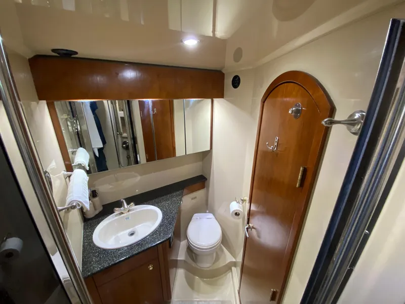 Slide: The Image of Luxurious 2006 Cruisers Yachts 52 Express bathroom with modern fixtures and wood accents. - 62
