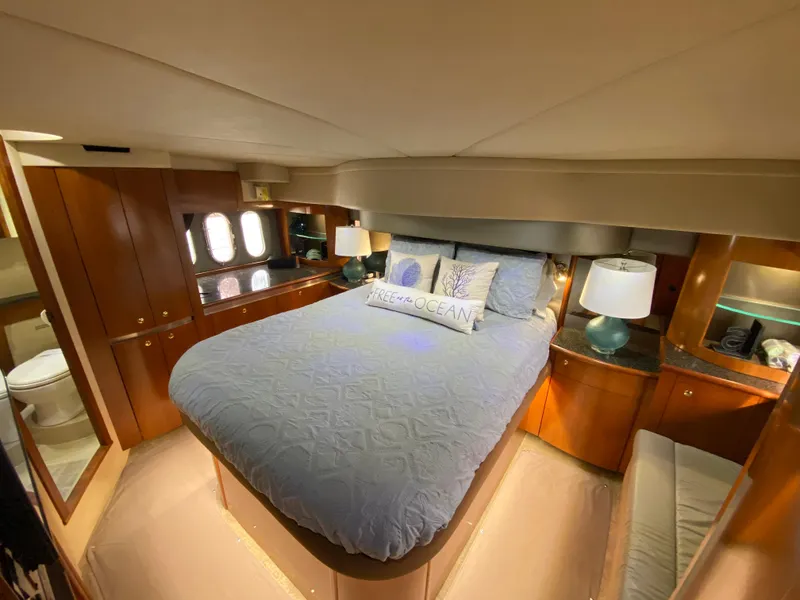 Slide: The Image of Luxurious bedroom in 2006 Cruisers Yachts 52 Express with elegant wood cabinetry. - 64