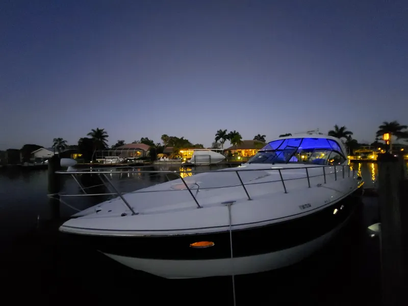 Slide: The Image of 2006 Cruisers Yachts 52 Express docked at night with blue cabin lights. - 7