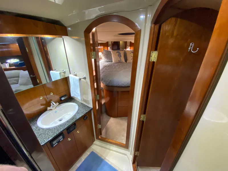 Slide: The Image of Luxurious 2006 Cruisers Yachts 52 Express bathroom with wood accents and cozy bedroom view. - 70